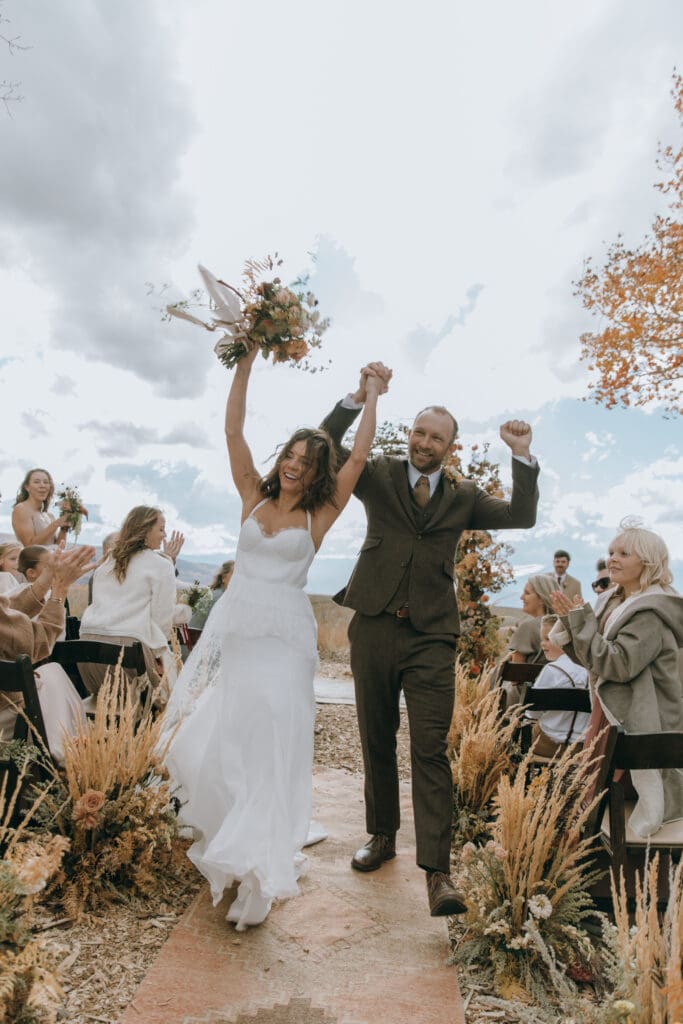 Bride and groom walking down the aisle of their luxury fall Park City Utah wedding