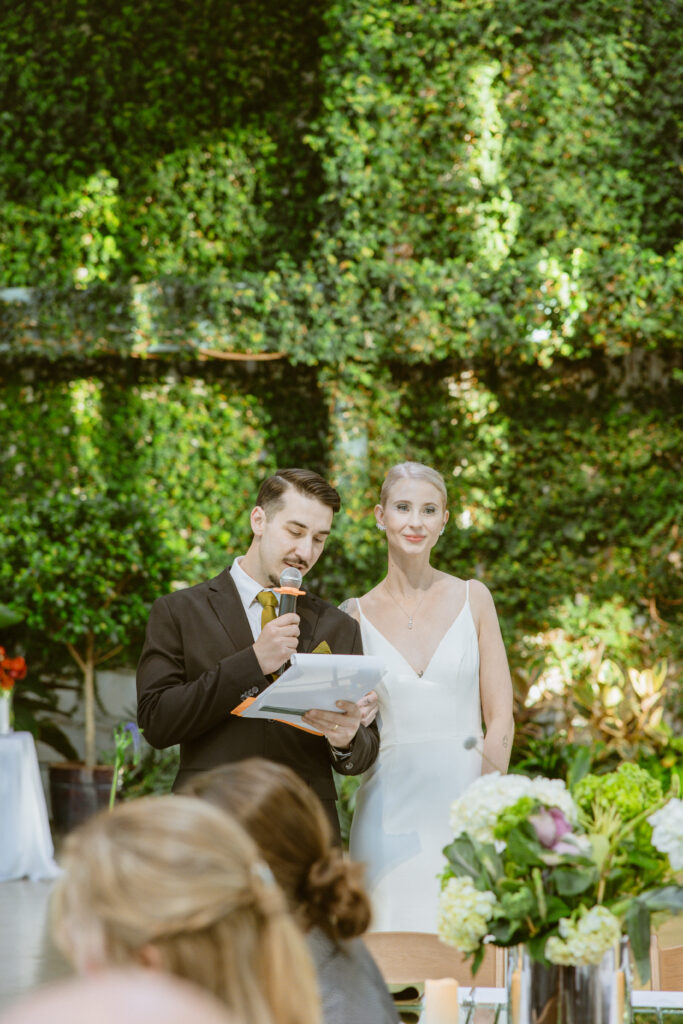 Groom giving wedding toast Red Butte Garden Orangerie living wall
