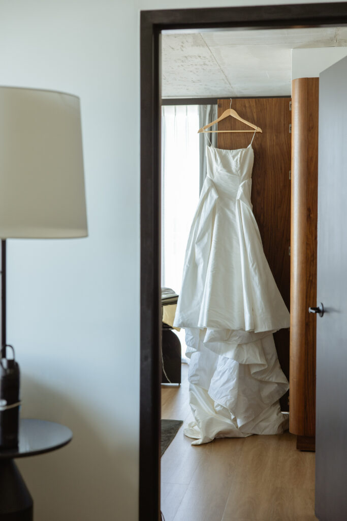 Wedding gown hanging in wood-paneled closet, Le Méridien Salt Lake City getting ready