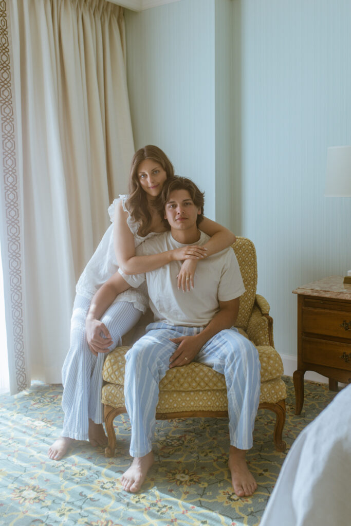 Bride and groom cuddling in vintage armchair during anniversary session at Grand America Hotel