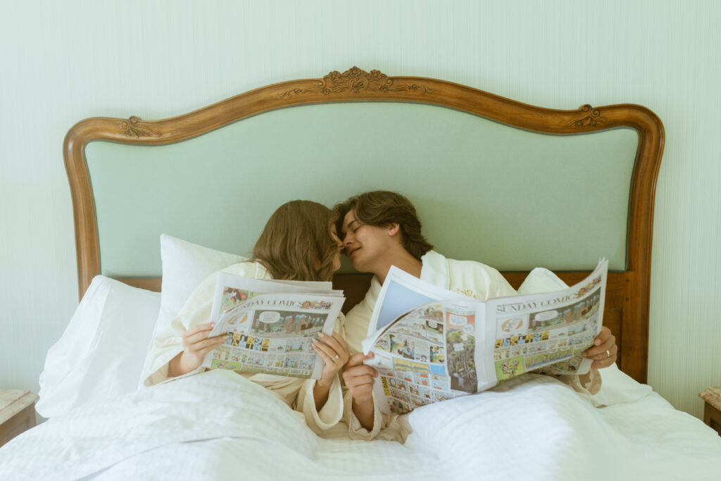 couple reading Sunday comics together in bed, whimsical anniversary session Salt Lake Cit