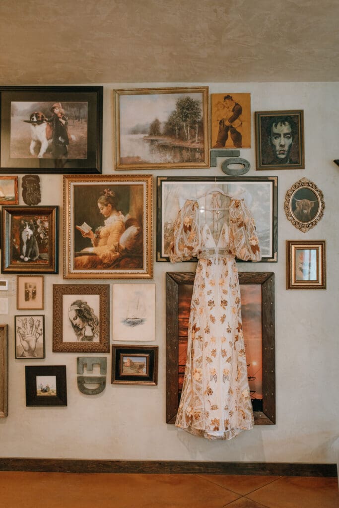 rue de seine wedding dress hung among an art wall at ring raven ranch in  Fort Collins Colorado 