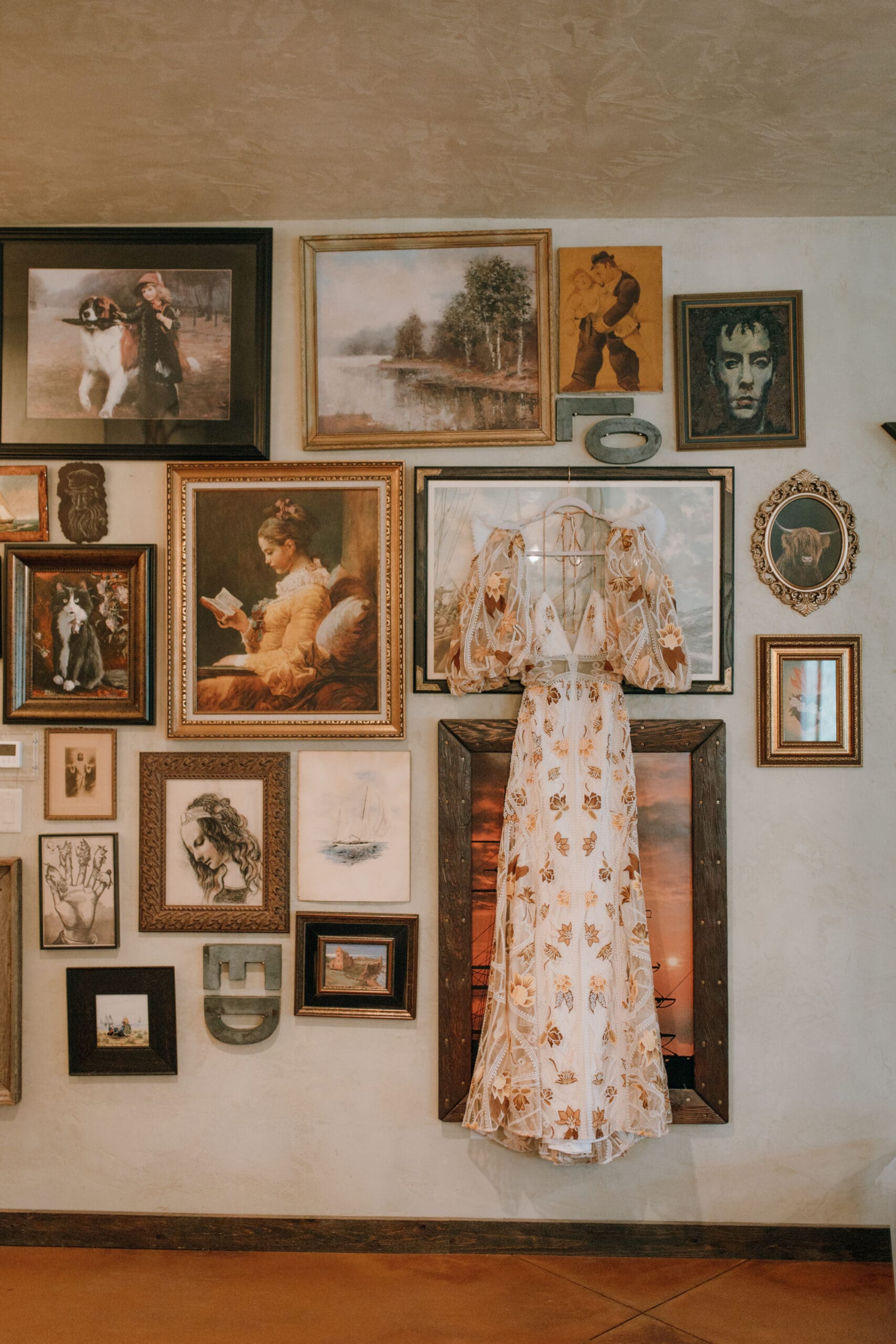 rue de seine wedding dress hung among an art wall at ring raven ranch in Fort Collins Colorado