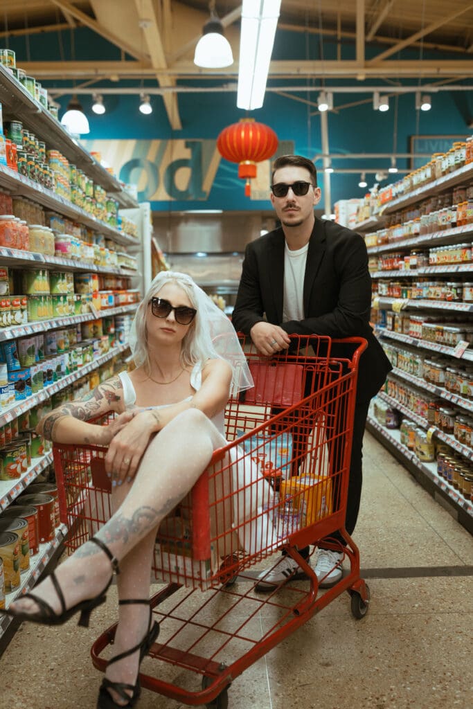 bride and groom cool poses in grocery cart